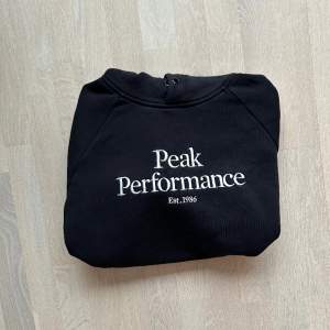 Svart Peak Performance Hoodie i ny skick använd ett fåtal gånger. Men saknar snöret som ska gå igenom luvan. Ny pris 1300kr  Storlek:L