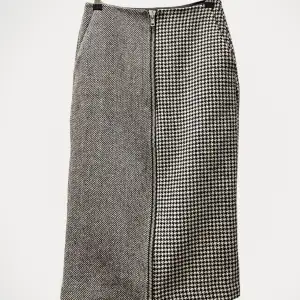 Kjol från Mads norgard, modell modell Bonded Wool Skirt.  Storlek: 34 Material: Viskos Nypris: 4000 SEK Använd, men utan anmärkning.  Kommentar från säljaren: Normal i storlek hundtandsmönstrad kjol med dragkedja