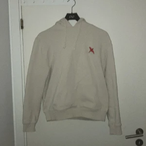 Arigato Hoodie - Beige Arigato hoodie med den klassiska fågeln på bröstet i rött. Strl S, lite liten i storlek så passar ungefär 170-175.