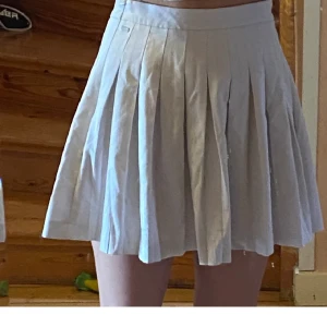 Vit tenniskjol - En vit tenniskjol. Har inga fläckar. Inga defekter. Köpt från H&M. Använd ett par gånger under sommarn