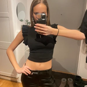 Volangtopp - Svart topp med volangärmar i stretchigt tyg. Knappt använd då jag tycker den är lite kort för min smak, så den ser ut som ny. Pris kan diskuteras. Köpare betalar för frakten