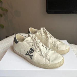 Sneakers ⭐️ - Vita sneakers från Scalpers i strl 38 med dödskallarna på sidorna. Skorna har ett ”smutsigt” utseende i modellen. Köparen står för frakt 🙌🏽
