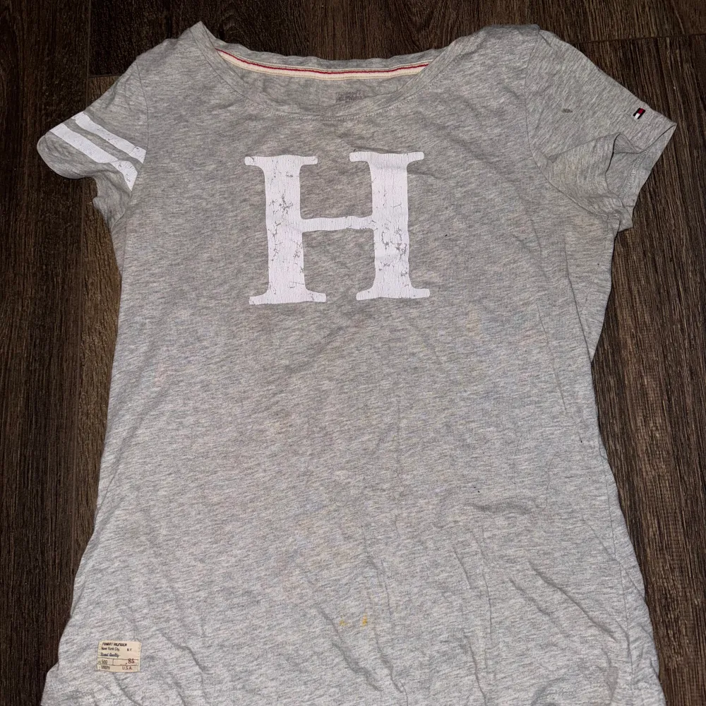 En grå tommy hilfiger t-shirt, använd ett par gånger men inga synliga defekter! Priset kan diskuteras!☺️💕. T-shirts.