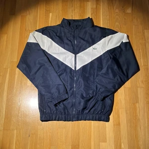 Vintage Lacoste Tracktop/vindjacka - Lite äldre Vintage Lacoste track top i mycket bra skick, fortfarande mycket att ge. Perfekt inför våren då materialet är väldigt tunnt och lätt. Sitter true to size. Skriv gärna vid funderingar👍