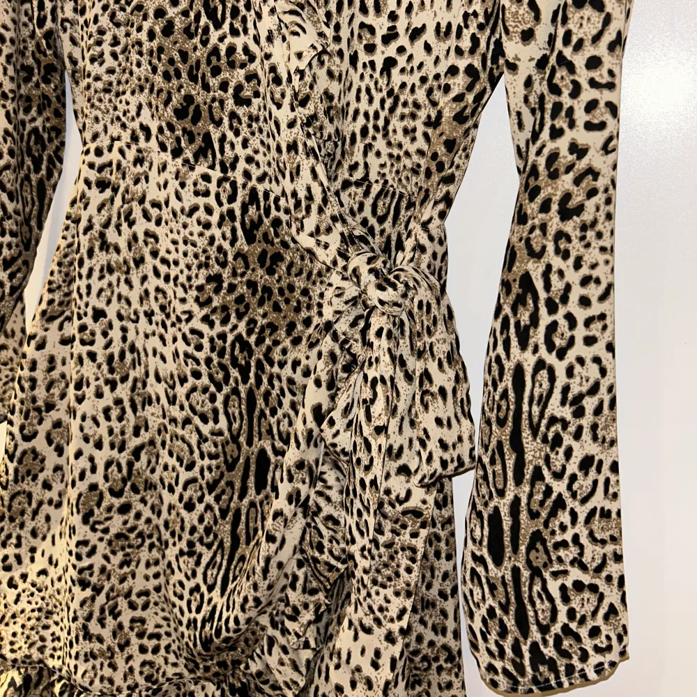 Omlott klänning med snörning på sidan. Leopard mönster. Köpt för ca 3 år sedan, minns ej vart, står Amelie & Me på lappen. . Klänningar.