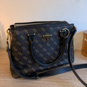 Guess väska - En mellanstor väska med en extra Axelrem till. 3 år gammal men knappt använd. Nypris 1799kr  
