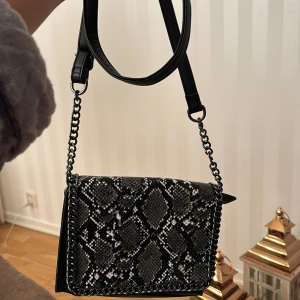 Väska  - En helt oanvänd väska som aldrig kommit till användning.Väskan är i ett jättebra skick och är i ett jättebra material.Den har ett långt band men du kan även göra den kort.🖤