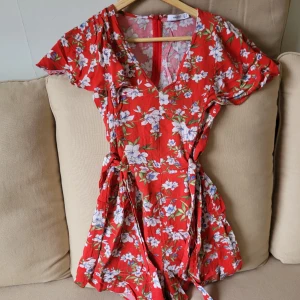 MANGO röd blommig playsuit - Så söt playsuit från Mango i röd färg med blommigt färgglatt mönster. Perfekt till sommaren med stråhatt och sandaler ❤️ Storlek: 34. Mått skickas på begäran, svarar på alla frågor.