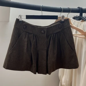 Isabel marant minikjol  - Kashmir och ull tyg. Mått ( platt ) midja: 42cm. Höft: 60cm. Längd: 36cm. Brun - grön färg. Kjolen har inget innertyg. Uppfattas som en strl M men kontrollera gärna måtten innan köp!! 