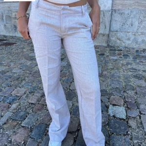 Kostymbyxor design by si  - Säljer ett par lågmidjade beige/gråa kostymbyxor/linnebyxor från design by si. De är aldrig använda och har lappen kvar. Slutsålda i denna storlek på hemsidan. Säljer pga att de var för stora för mig🥰nypris 726 kr