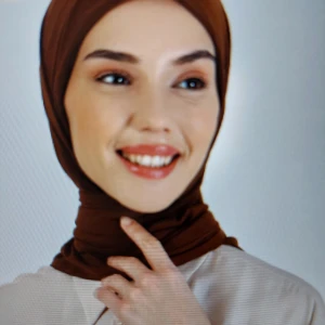 Brun Harem Halsduk - Säljer en elegant brun halsduk från Harem. Halsduken är tillverkad i ett mjukt och bekvämt material som känns skönt mot huden. Den har en enkel och klassisk design som passar till alla outfits.