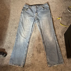 Blå jeans med slitna detaljer - samma som dem gråa (loose fit) med resoren och måtten är W40cm L102cm och benöppningen är 22cm. Litet slitage nere vid benöppningen annars rätt bra skick. 