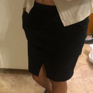 Svart kort kjol - Svart kort kjol med fickor och en slits vid benen , ingen användning  Skriv för frågor och fler bilder