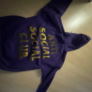Lila hoodie från Anti Social Social Club - Säljer en snygg lila hoodie från Anti Social Social Club. Den har en stor gul text på ryggen och en mindre text på bröstet. Hoodien är perfekt för höst och vinter, och den är superbekväm med sin mjuka insida. Passar perfekt för en casual look eller när du bara vill mysa hemma. 🟣💛