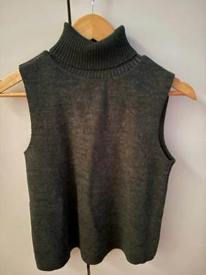 Mörkgrön stickad poloväst - Mörkgrön stickad poloväst från Zara, storlek S men lite mindre i storlek passar Xs också. Använt fåtal gånger och inga defekter.