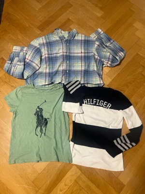 Säljer perfekt kapselpaket! Ralph Lauren & Tommy Hilfiger – Trendig Oversized & Clean Preppy Look - Det perfekta färdiga paketet för dig som vill spika den rätta oversized-looken!   Grön Ralph Lauren T-shirt (M): Klassisk, fräsch bas-tisha med ikoniska Big Pony.   Rutig Ralph Lauren Skjorta (XL): Perfekt oversized! Snygg att bära öppen över t-shirten eller över axlarna.   Tommy Hilfiger Tröja (L): Otroligt mjuk och len tröja i snygg blockfärg. Mysig och lyxig känsla! Tveka inte att fråga något😊