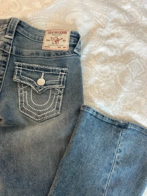True religion jeans - Säljer ett par blåa true religion jeans med W24. Dem är nyköpta på raglady, men säljer då jag ångrar köpet… helt felfria annars. Skit coola diamant fickor. Lågmidjade och bootcut i modell.