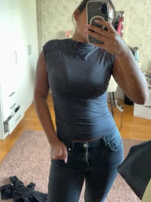 Grå topp från Gina  - Säljer en grå, tight och ärmlös topp med hög hals från gina. Strechigt material som sitter figurnära. Storlek S. Säljer för 100kr. 