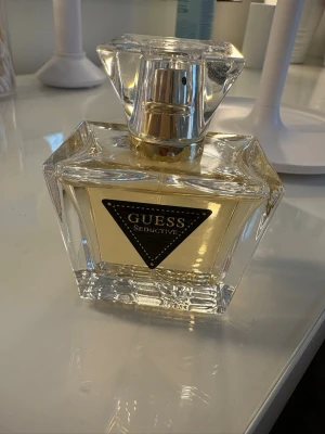 GUESS Seductive Eau de Toilette 50ml ✨ - Klassisk och blommig/fruktig damparfym från Guess. Flaskan är på 50 ml och är näst intill full, knappt använd (se tidigare bilder för exakt mängd).🌸  Märke: GUESS  Doft: Seductive EdT  Storlek: 50 ml  Doftnoter: Bergamott, svarta vinbär, päron, jasmin, vanilj och cashmeran.  Skick: Sparsamt använd / Nästan full flaska. Kommer utan originalkartong. Skriv om du har några frågor!💗