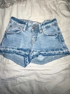 Ljusblå denimshorts med rå kant - Helt nya shorts de är aldrig använda,  ja kommer att tvätta dem innan ja skickar iväg, hund o katt finns i hemmet💗