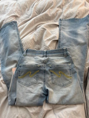Nelly jeans - Säljer ett par jättefina jeans med gula detaljer från Nelly som aldrig kommit till användning!!