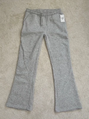 Gråa low waist mjukisbyxor  - Ett par ljusgrå low waist mjukisbyxor från Favourite i storlek 170. Byxorna är helt nya med prislappen kvar och säljer pågrund av att de inte passade.