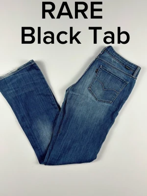 Rare Black Tab Levi's bootcut jeans blå W29 L32 - RARE Levi's Black Tab jeans med riktigt snygga detaljer. Från Always Honestly Made kollektionen. Väldigt unika jeans! Unisex Färg: Blå Passform: Bootcut Storlek: W29 L32 Skick: B Grade Mått [platt] (±1 cm): A: 39 cm B: 103 cm C: 26 cm D: 21 cm Tveka inte att höra av dig vid frågor eller funderingar.  Skickas snabbt!