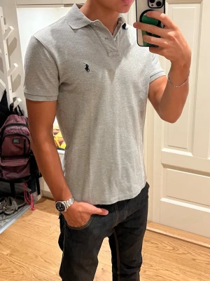 Grå Ralph Lauren Piké - Klassisk grå pikétröja från Polo Ralph Lauren. Den har en skön passform, lite tajtare längs armarna. Storlek S. Inga defekter. Skriv om du undrar något🤙