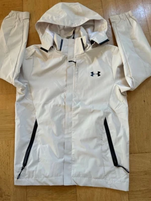 Under armour jacka - Säljer en skön jacka från under armour den skyddar mot vind regn och snö. Köpte den för 1300 här på plick med prislappen men bör jag fick den hade den ingen prislapp men den är helt ny och aldrig använd, den är m men känns som s så skriv gärna privat för frågor som typ måtten och kom gärna med bud👍