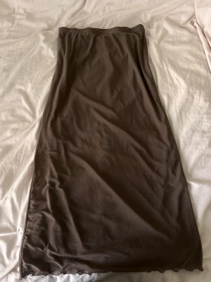 Brun långkjol i mjukt material - Säljer en enkel och stilren brun low waist långkjol i mjukt, stretchigt material. Kjolen har en rak passform och resår i midjan för extra komfort. Perfekt att matcha med en crop top eller oversized tröja. Från shein