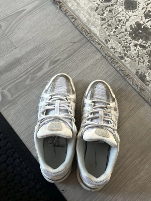 Vita mesh sneakers med grå detaljer - Snygga vita sneakers med grå detaljer och meshpaneler för extra ventilation. Skorna har en chunky sula och klassisk snörning. Perfekta för dig som gillar sportig och clean stil.