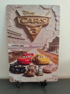 Disney Cars 3 metallskylt - Cool metallskylt med motiv från Disney Cars 3. Skylten har färgglada karaktärer från filmen och texten 'Florida 5000' och 'Thunder Rally'. Perfekt som dekoration i barnrummet eller för samlare av Disney-prylar.