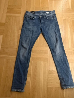 Blå slim fit jeans från Dondup - Snygga blå slim fit jeans från Dondup, tillverkade i Italien.Perfekta för dig som gillar en smal siluett och tidlös denimstil.gammalt hål nere vid rumpan som är igensytt snyggt 