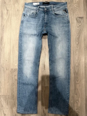 Replay Rocco Jeans Ljusblå W33/L34 - Regular Fit - Replay Rocco ljusblå jeans med regular fit-passform som sitter klassiskt och bekvämt med rakare ben, storlek W33/L34, midja 41 cm, ytterbenslängd 107 cm, benöppning 19 cm, modellen är 185cm & väger 65kg, i fint skick.