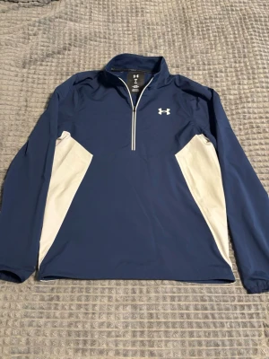 Under armour golf tröja - Super snygg och clean golftröja från under armour som endast är använd några få gånger.          Storleken är M och har även remmar så man kan justera storleken vid magen.