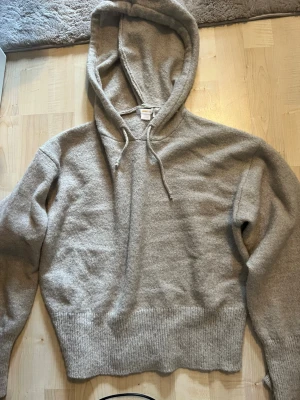Beige stickad hoodie och tröja - Två stickade tröjor i beige toner. Ena är en hoodie  bred ribbad mudd 146/152, den andra är en vit stickad tröja från LMTD med strukturmönster och rund hals. Båda har långa ärmar och mjukt material, perfekta för kyliga dagar. Stl 13-14 s. Tar alla bud!