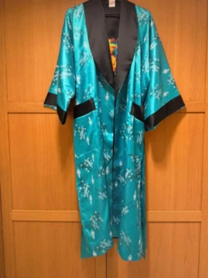 Vändbar kimono i satin, turkos & svart - Snygg vändbar morgonrock i satin med ena sidan turkos och blommönster, andra sidan svart med turkosa detaljer. Vida ärmar och knytskärp i midjan. Perfekt för chill dagar hemma och ger en lyxig känsla. Stlk M-L , fin skick 