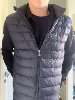 Ralph Lauren Väst - Säljer en stilren mörkblå dunväst från Ralph Lauren🏇 Västen är i nytt skick utan några defekter. Storleken är L men passar M. Perfekt inför kommande hösten med kallare dagar🍁 QR koden är kvar och visar att den är helt äkta! Tveka inte på att fråga😁