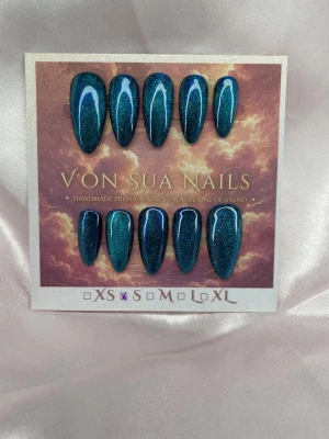 Nerissa (S);Medium Almond - Handgjorda press-on nails i Medium Almond med djup teal cat eye-effekt. Det magnetiska skimret skiftar mellan mörkblått och turkost beroende på ljus och vinkel.  Storlek: S Form: Medium Almond 10 handgjorda naglar Prep-kit medföljer.