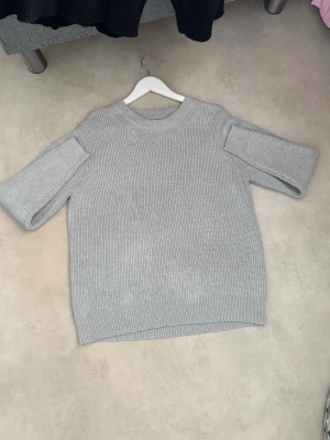 Grå ribbstickad tröja Maison Margiela - Säljer en stilren grå ribbstickad tröja från Maison Margiela. Tröjan har korta ärmar, rund halsringning och är gjord i ett mjukt, tjockt material. Perfekt för lager på lager och enkel att matcha med olika outfits.Priset kan diskuteras 🍾