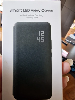 Samsung Smart LED View Cover S22+ - Snyggt svart mobilskal med LED-display för Galaxy S22+. Fodralet har smarta notifikationer på framsidan och antimikrobiell beläggning. Perfekt för dig som vill ha både skydd och stil i ett och samma skal.