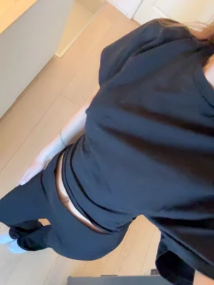 Svart croppad t-shirt - Säljer en svart croppad t-shirt med korta ärmar och rund hals. T-shirten har en loose passform och är tillverkad i mjuk bomull, perfekt för en avslappnad och trendig look.