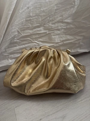 Guldig metallic kuvertväska - Guldig clutch använd endast en gång perfekt till bal eller annat event☀️ band finns med!