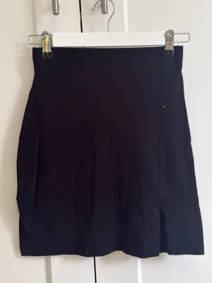 Svart kortkjol med slits - Enkel svart kortkjol med en fin slits. Formar sig fint efter formen och har en lite högre midja. Köpt på zalando märke even&odd och bara använd en gång💗