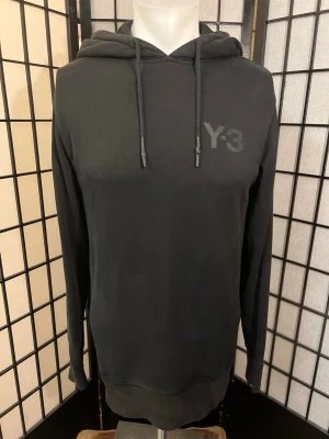 Y-3 Hoodie Black – Yohji Yamamoto x adidas 🖤 - 🖤 Stilren Y-3 hoodie från adidas x Yohji Yamamoto i svart med ton-i-ton Y-3-logo på bröstet. Premiumkvalitet och minimalistisk design som passar till allt.  📏 Ca 48 cm pit to pit, 43–44 cm axlar och 68 cm längd.  Skick: Bra begagnat skick. Ett mycket litet hål på magen samt tre små märken/revor på höger axel (se bilder). I övrigt fin och fräsch. 🔥