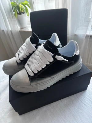 Numeris skor  - Snygga sneakers i svart och vitt med breda vita skosnören och kraftig sula. Ovandelen är i svart med vit tå och häl, samt vita detaljer. Sulan är gråvit och har ett räfflat mönster undertill. Perfekta för dig som gillar en modern och chunky look. Köpta ifrån hemsidan. Aldrig använda. Även öppen för byten!