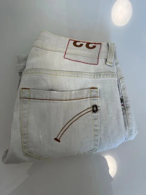 Vita dondup jeans  - L33 w33Säljer ett par vita fondue med original slitningar jeans med unik broderad bakficka och kontrastsömmar. Jeansen har en patch med två bruna C på linningen och raka ben. Perfekta för dig som vill sticka ut med detaljer!
