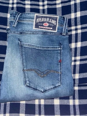 Replay Anbass jeans  - Snygga blåa replay Anbass jeans. Midja 43cm, längd 99cm. Längd storleken saknas, men jag skulle bedöma till L32 -men  utgå efter mått. Obs jeansen har en liten fläck baktill på låret. Samt vänstra framfickan är det ett hål i. JAG SKICKAR EJ FLER BILDER NÄR JAG BÄR JEANSEN! för bättre inblick i passformen rekommenderar jag att googla på modellnamnet. För storleksguide kolla måtten noggrant då jeansen alltid kan vara uppsydda heller krympta och jag ej tar emot returer :) (r29)