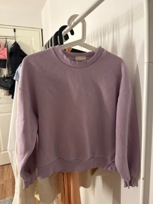 Ljuslila sweatshirt från Gina Tricot  - Säljer en ljuslila sweatshirt från Gina Tricot i storlek XS. Tröjan har rund halsringning, ribbade muddar vid ärmslut och nederkant samt en avslappnad passform. Materialet känns mjukt och bekvämt.