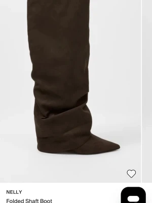 Bruna slouchy stövlar med spetsig tå - Säljer ett par höga, bruna stövlar med slouchy skaft och spetsig tå. Stövlarna har en mjuk mockaliknande yta och en bred passform upptill. Perfekta för att lyfta vilken outfit som helst. Använda en gång